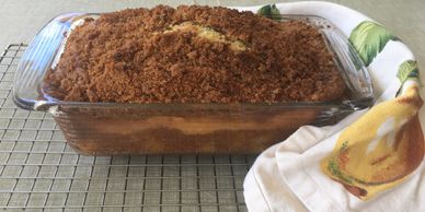 Peach Pound cake in a glass loaf pan and cooling rack.