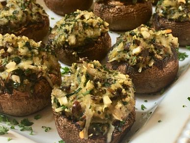 Stuffed Mushrooms served on a white serving platter and garnished with fresh parsley.