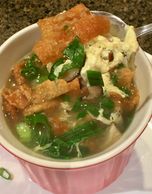 Egg drop soup with shiitake mushrooms and green onions topped with crispy wonton strips.