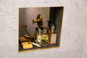 Background black mirror/ shower niche/ brass trim.  