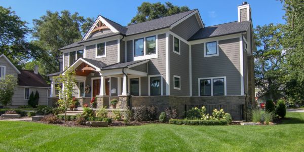 Modern two-story house with gray siding and a well-maintained lawn.