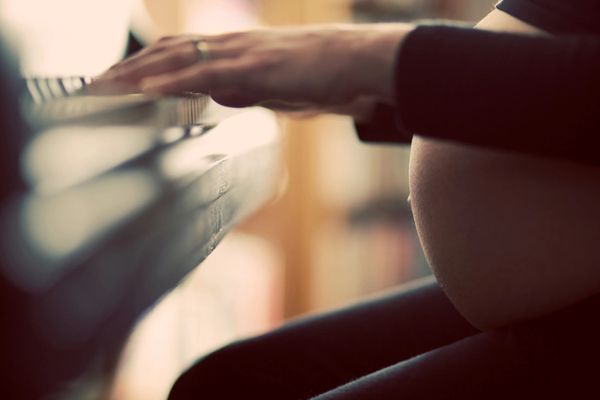 Pregnancy photography of woman playing piano