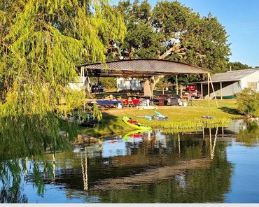 family group reunion party covered shade pavilion outdoor kitchen grill picnic Lakefront kayaks floa