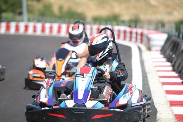 Go-kart racers navigating a track turn.