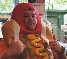A man wearing a hot dog costume with both his thumbs up. 
