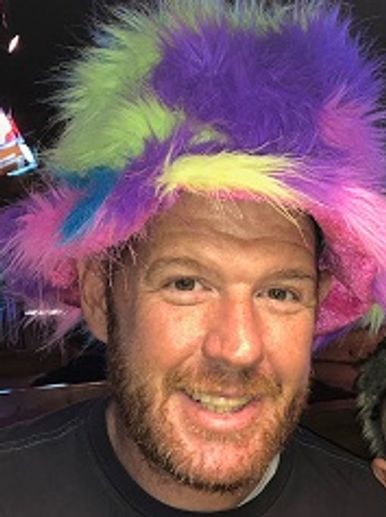 a man wearing a fuzzy, multi-colored hat. 