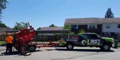 Men at work filling potholes with hot asphalt.