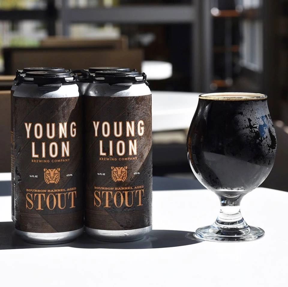 YLBC 4 pack cans of Bourbon Barrel Stout with a poured glass of stout next to it.