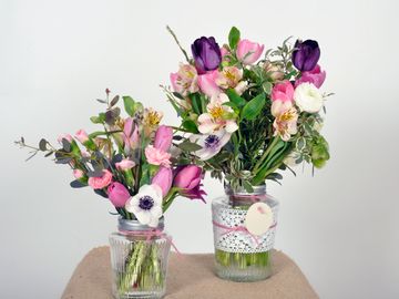 Two jars with pink and white floral displays