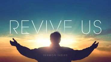 Silhouette of a person with arms open under the words 'Revive Us' at sunrise.