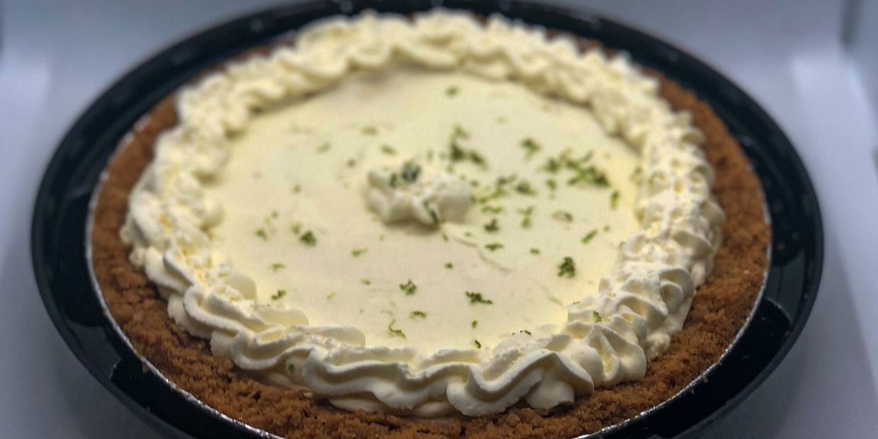 Big key lime pie topped with whipped cream and lime shavings.