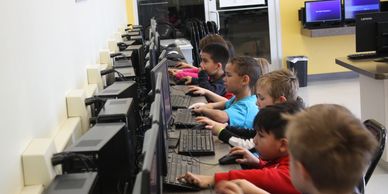 Children focused on computers in a classroom setting.