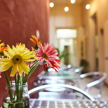 Colorful flowers in a vase on a table in a cozy indoor setting.