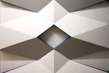 Geometric ceiling design with a diamond-shaped opening and sharp angular patterns.