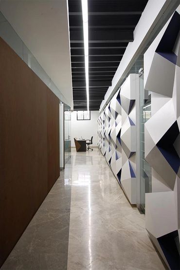Modern hallway with geometric wall art and sleek office furniture.