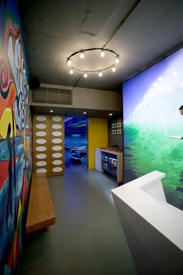 Modern surf shop interior with vibrant wall art and surfboards.