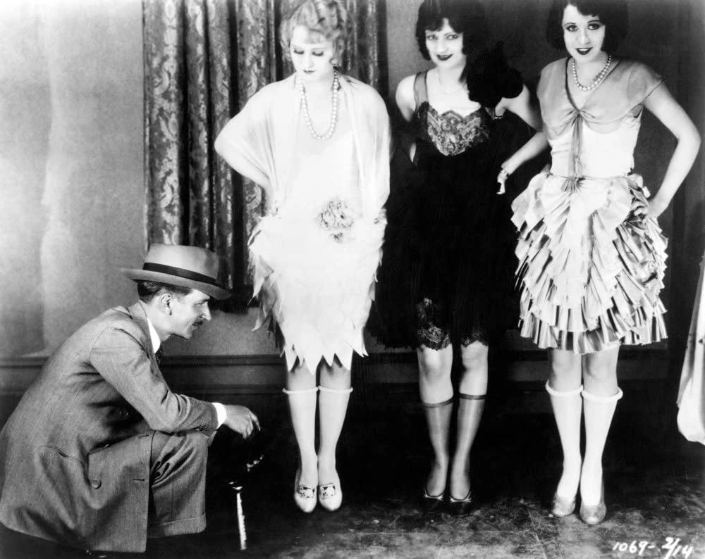 Three 1920s Ladies in flapper dresses and rolled down stockings