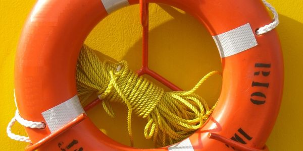 Orange life buoy from Rio de Janeiro against yellow background.