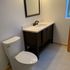 Toilet, medicine cabinet, light fixtures, vanity, tiled bathroom floor installation. Heated bathroom