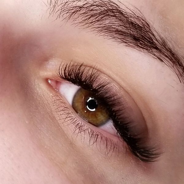 Close-up of a brown eye with long eyelashes.