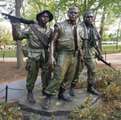 Statue of three soldiers in military gear holding rifles.