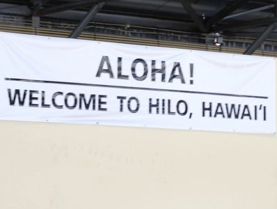 a welcome sign hanging from the side of a building