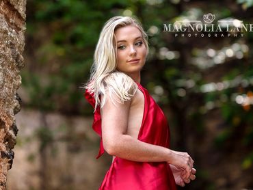 Outdoor portraits young blonde model wearing a red dress.