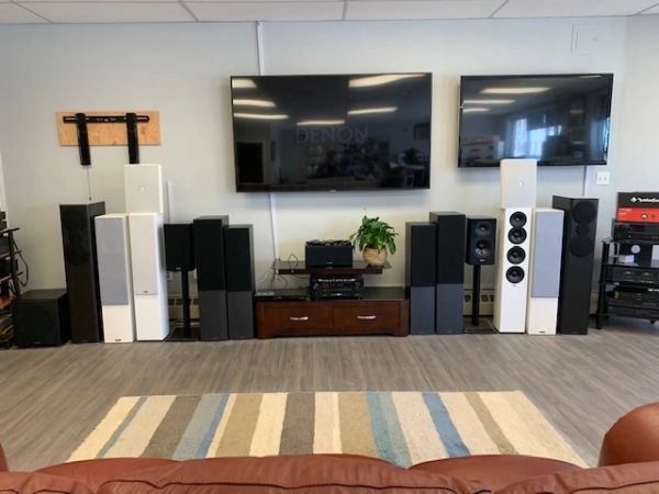 Home theater setup with multiple speakers, two large TVs, and audio equipment.