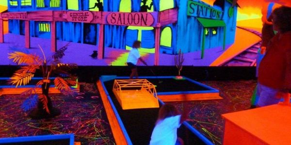 Black light indoor mini golf course lit up.