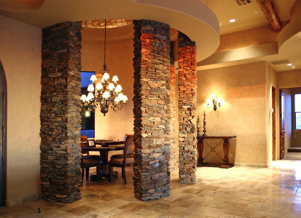 Natural ledge stone used in tall columns surrounding a traditional dining room.