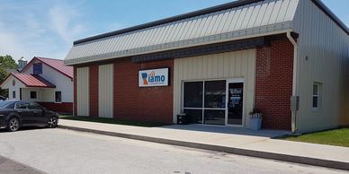 Exterior of a brick and metal building with the Iamo sign on the wall.