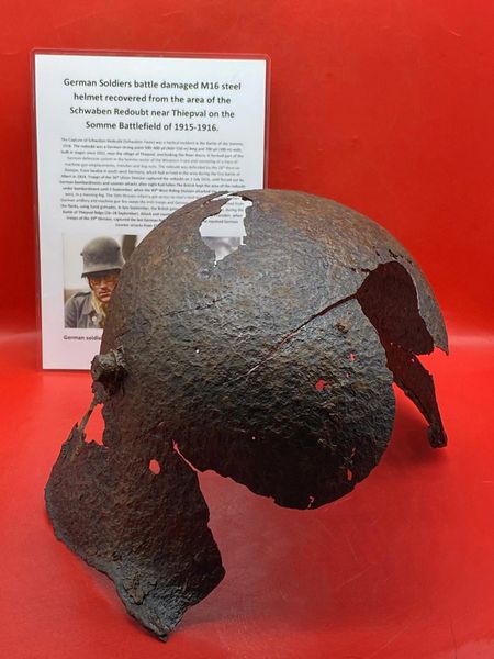 German soldiers battle damaged M16 helmet remains recovered from the area of Schwaben Redoubt near Thiepval on the Somme battlefield of July 1916.