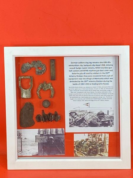 Glass framed group of relics including medals,gun parts 1938 dated clip all recovered in the area of the village of Marinovka which was defended by the 297th Infantry Division during the battle of 1942-1943 at Stalingrad