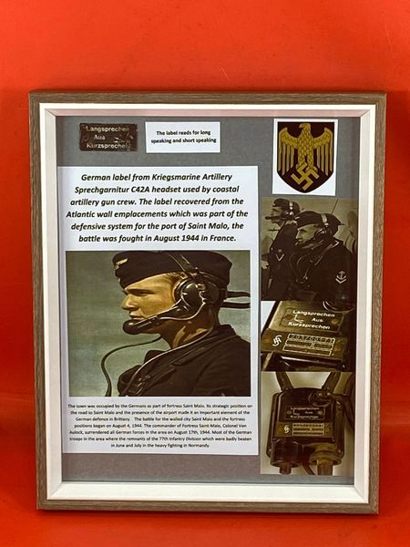 Glass framed display German label from Kriegsmarine Artillery Sprechgarnitur C42A headset used by coastal artillery gun crew recovered from the Atlantic wall emplacements part of the defensive system for the port of Saint Malo, the battle August 1944