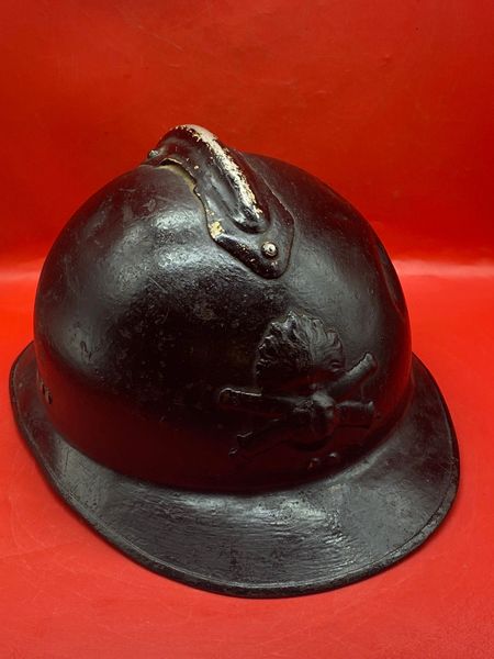 French soldiers artillery M1926 Adrian helmet complete with liner and chinstrap and over painted black for use in civil defense from a brocante near Paris.