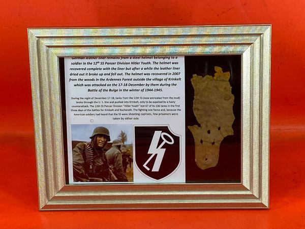 Glass framed German leather liner remains from a steel helmet from a soldier in the 12th SS Panzer Division Hitler Youth it was recovered in 2007 from the Ardennes Forest at Krinkelt attacked in December by them during the Battle of the Bulge-1944-1945.