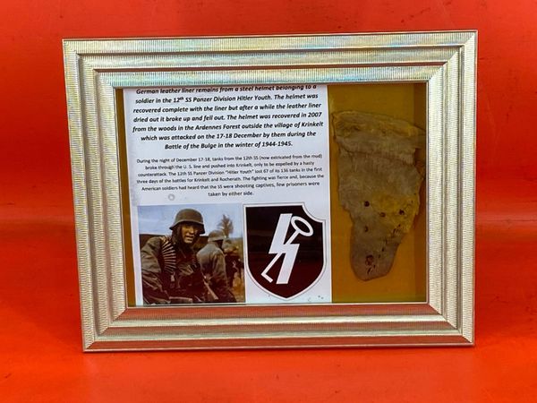 Glass framed German leather liner remains from a steel helmet from a soldier in the 12th SS Panzer Division Hitler Youth it was recovered in 2007 from the Ardennes Forest at Krinkelt attacked in December by them during the Battle of the Bulge-1944-1945.