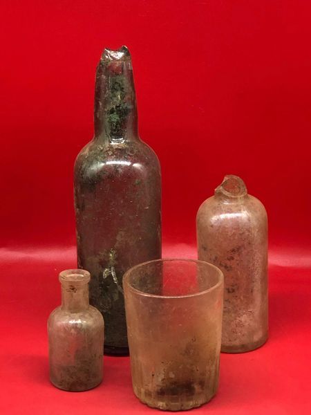 Group of German glass bottles and drinking glass with dirt remains inside recovered in 2016 from,Regina Trench near Courcelette on the Somme battlefield of mid October 1916