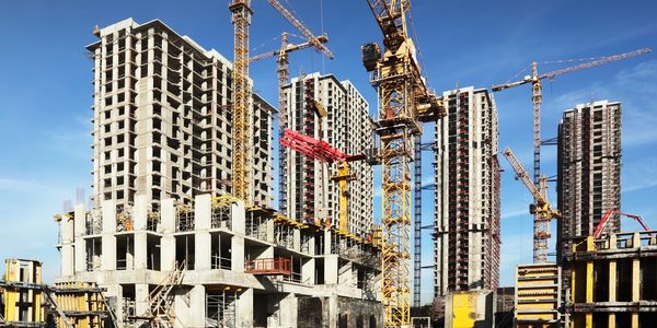 Inside place for many tall buildings under construction and cranes under a blue sky