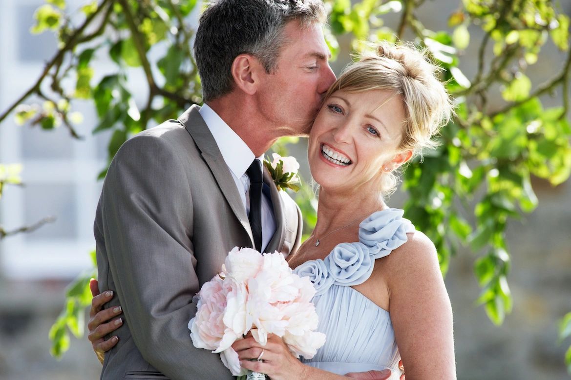 Groom kissing the bride on the cheek