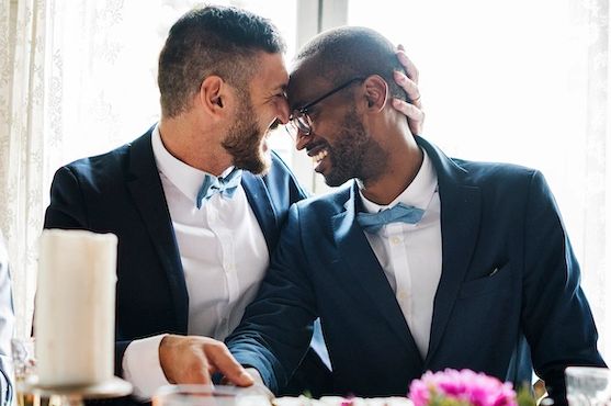 A gay couple kissing smiling at each other