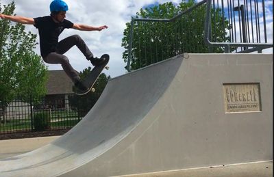 Dr. Leins doing an ollie on a skateboard on a quarterpipe. 