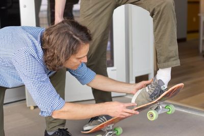 Dr. Leins analyzing a patient's legs while they are balanced on a skateboard. 