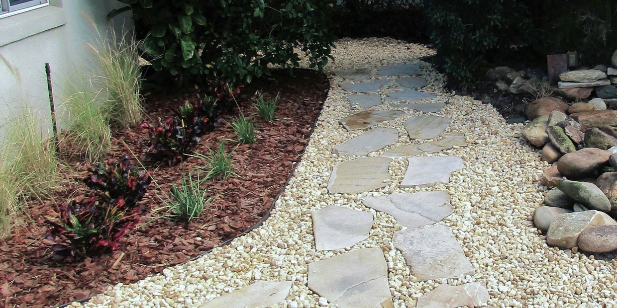 rock pathway with pavers, mulch, and plants