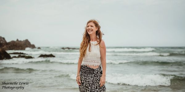 Female standing in the waves smiling