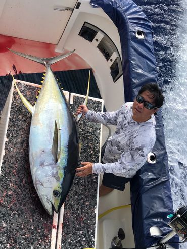 tahiti sport fishing guest poses with big yellow fin tuna