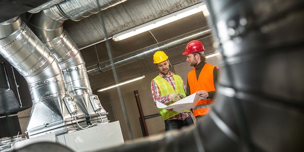 Two construction planning guys on a work site reviewing plans. 