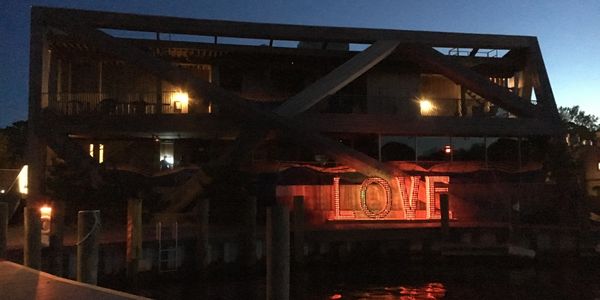 The main entertainment and office building featuring The Pavilion and Sip 'N Twirl clubs, Pines Pizza, realtor offices, and much more - as seen from the Harbor Walk and ferry dock.