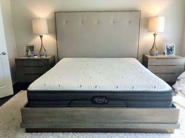 Completed cleaning of a king size mattress on a low-profile bed in between two nightstands.
