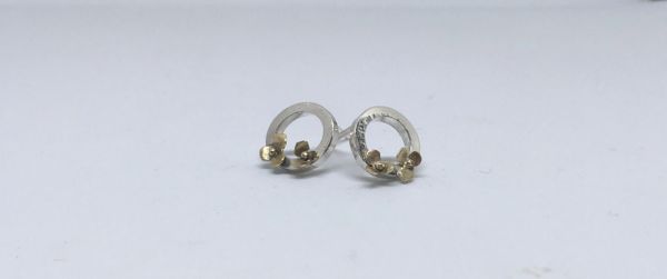 Silver circles decorated with tiny handcut gold flowers